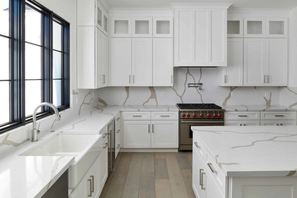 White kitchen counters and cabinets using Bianco Levanto Quartz for backsplash and counters - Fairmount Development Design using Arizona Tile