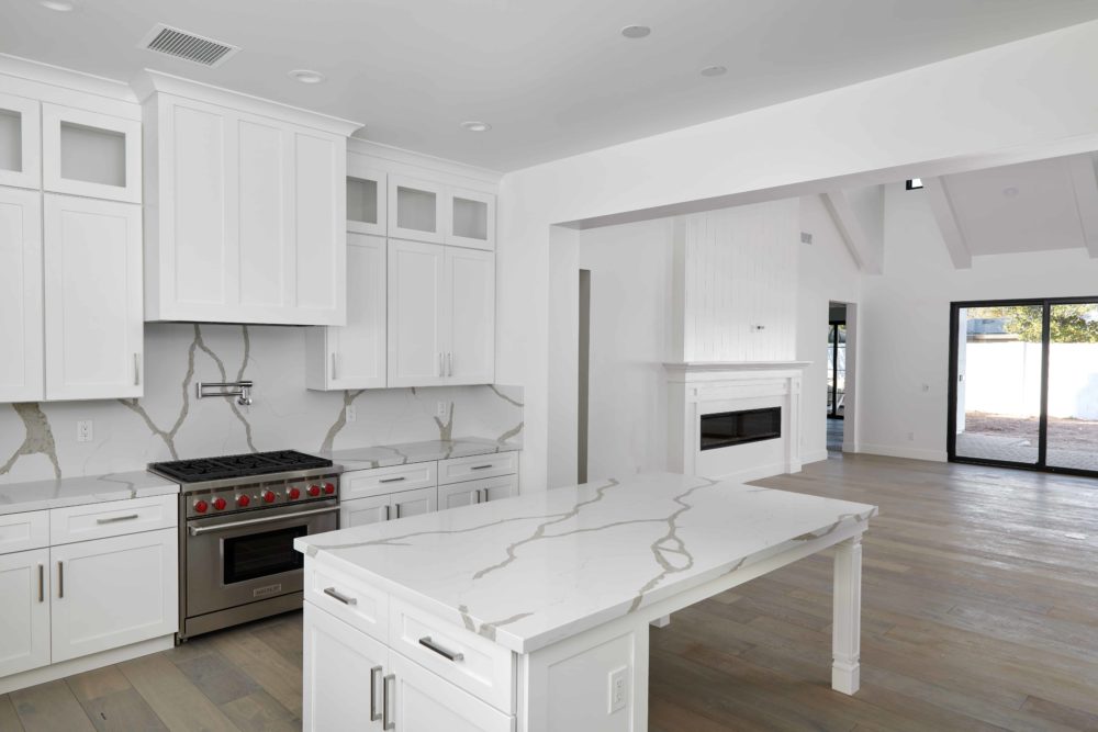 White kitchen island with Bianco Levanto Quartz countertop - Fairmount Development Design using Arizona Tile