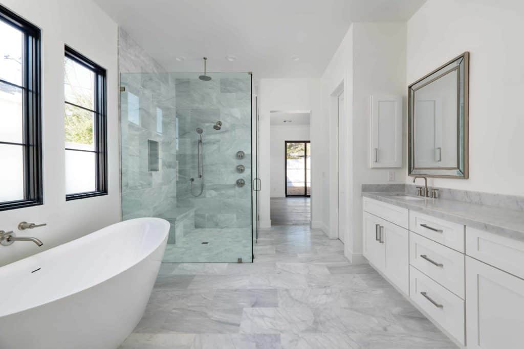 Newly remodeled master bathroom with marble counters and glass enclosed shower - Fairmount Development Design using Arizona Tile