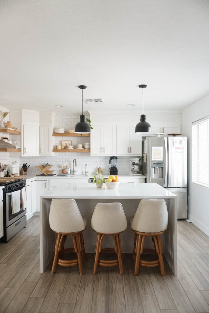 Newly remodeled kitchen with island barstools and refrigerator